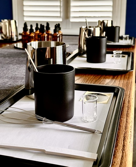 Candle-making workshop table set up with fragrance oils and materials